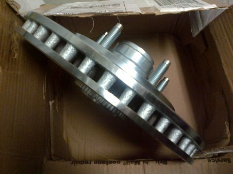 2003 Ford F-150 - A brake rotor and hub assembly is shown inside a cardboard box, with visible text on the box.