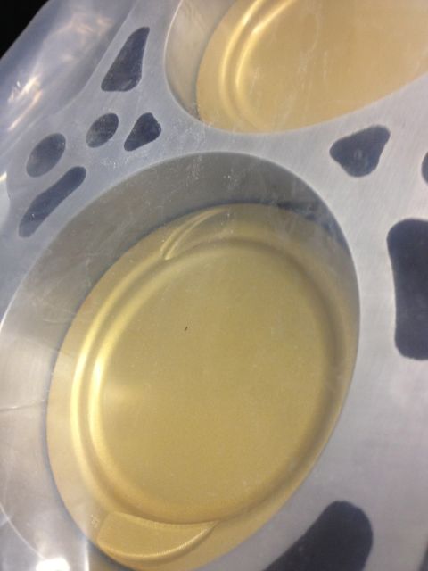 1992 Ford Crown Victoria - Close-up of engine pistons within a cylinder head, revealing their golden surfaces.
