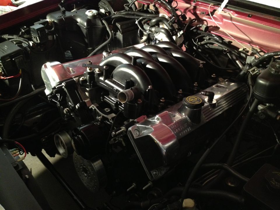 Engine bay showing a custom intake manifold and polished valve covers