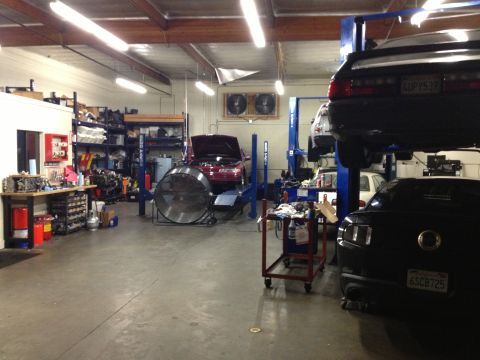 1992 Ford Crown Victoria - A busy auto repair shop with several vehicles being serviced.