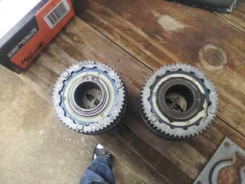 1988 Ford Bronco - Two automatic locking hubs are shown on a wooden table next to a box and a tool.