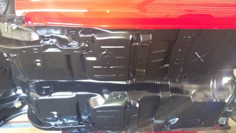 1972 Pontiac Trans Am - The underside of a car, showing the frame and floor pan, with a red body panel above.