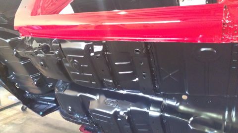 1972 Pontiac Trans Am - The black undercarriage of a vehicle is visible, with red body panels above.