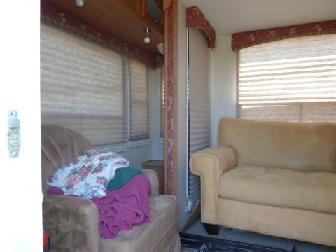 1992 Ford Mustang - The interior of a camper shows a living area with seating and blinds covering the windows.
