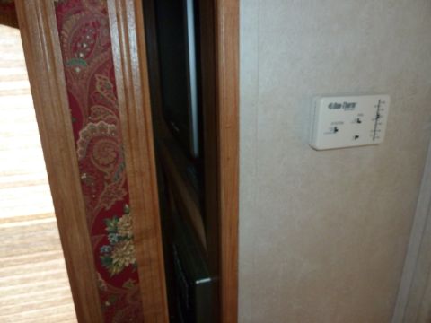 1992 Ford Mustang - Interior view of an RV, showing wood trim, wallpaper, and a wall-mounted thermostat.