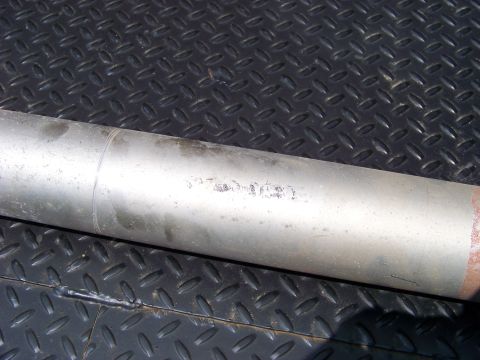 1999 Mercury Grand Marquis - A close-up shows an exhaust pipe with faint markings, placed on a textured metal surface.