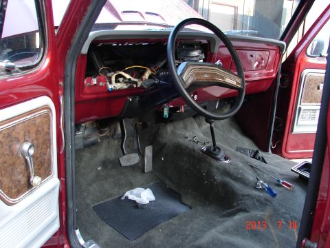1979 Ford F-150 - The interior of a 1979 Ford F-150 shows exposed wiring under the dashboard and a manual shifter on the floor.
