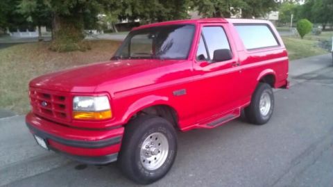 1988 Ford Bronco - This red Ford Bronco is shown from the front three-quarter angle.