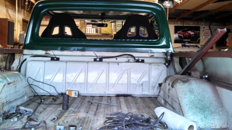 1967 Ford F-250 - The interior of a 1967 Ford F-250 pickup truck, modified with racing seats and various items in the bed.