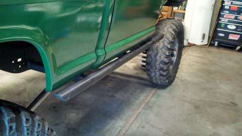 1967 Ford F-250 - A green pickup truck is shown from the side, large tires and custom rock sliders.
