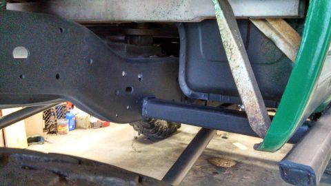1967 Ford F-250 - Underside view of a 1967 Ford F-250 frame, showing the chassis components and a portion of the green body.