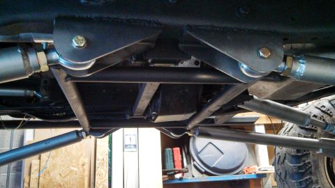 1967 Ford F-250 - Close-up view of the undercarriage, highlighting custom suspension modifications and heavy-duty linkages.