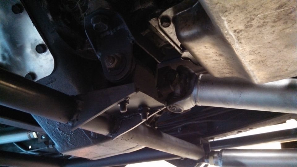 Underside view of truck frame with driveshaft and exhaust components