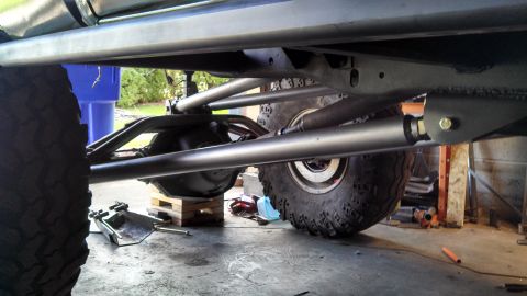1967 Ford F-250 - The underside of a modified truck, showing its robust suspension components and large off-road tires.