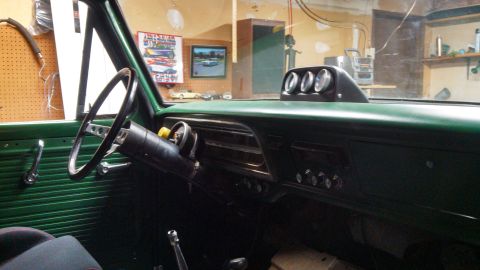 1967 Ford F-250 - Interior view of a 1967 Ford F-250, green paneling and a trio of aftermarket gauges mounted on the dashboard.