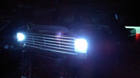1967 Ford F-250 - Front view of a 1967 Ford F-250, highlighting its distinctive grille and illuminated headlights.