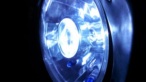 1967 Ford F-250 - A detailed view of a vehicle's headlight, illuminated with a bright blue light.