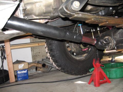 1993 Toyota 4Runner - The underside of a vehicle shows the driveshaft and differential assembly, with a tire and exhaust components in view.