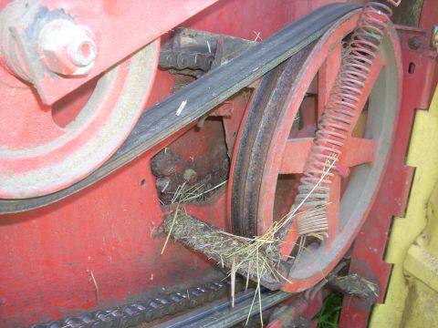 1963 Hummer H3 - Internal components of a baler, including a drive belt and chain, with visible hay residue.