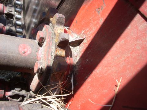 1963 Hummer H3 - Detail of a gear and chain mechanism on a red piece of farm equipment, likely a baler.