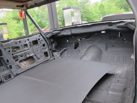 1991 Ford LTD Crown Victoria - The interior of a car is shown stripped down to its metal frame, revealing the bare floor and door panels.