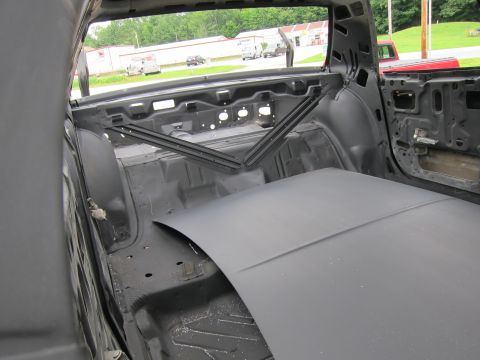 1991 Ford LTD Crown Victoria - The interior of a car, stripped down and prepped for restoration, reveals its bare metal structure and primer coating.