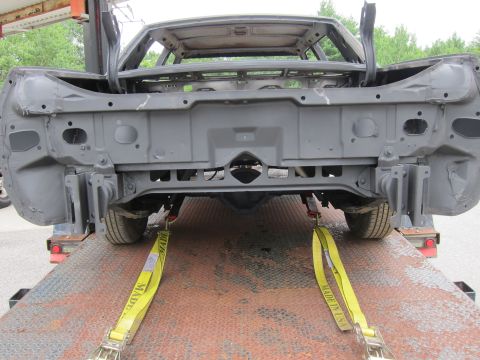 1991 Ford LTD Crown Victoria - Car body being transported on a trailer, showing the rear frame and suspension components.