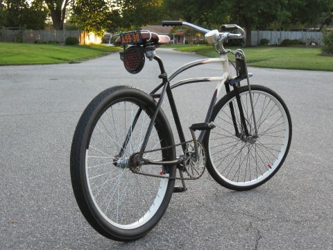 1994 Ford Bronco - A custom bicycle with a unique frame design and a vintage license plate is parked on a suburban street.