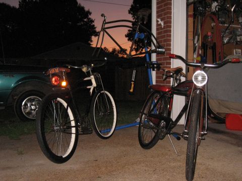 1994 Ford Bronco - Two bicycles are parked in a driveway at dusk, with a teal car visible to the left.