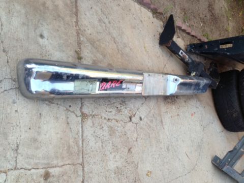 1986 Ford Bronco - A chrome bumper with a "DARE" sticker is shown lying on the ground.