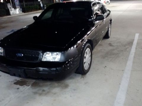 2008 Ford Crown Victoria - A black 2008 Ford Crown Victoria is parked in a lot at night.
