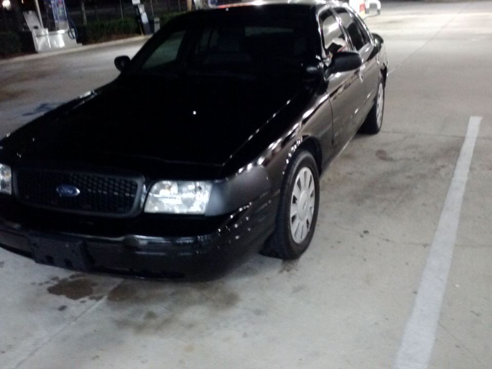 Black 2008 Ford Crown Victoria parked on concrete, front quarter view