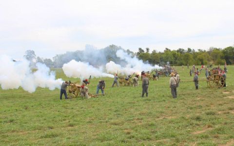 1979 Ford Bronco - A historical reenactment unfolds with cannons firing, creating plumes of smoke across a green field.