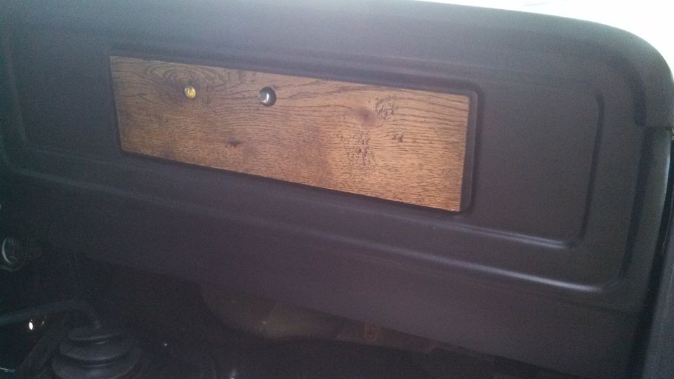 Dashboard panel with woodgrain trim and two circular openings