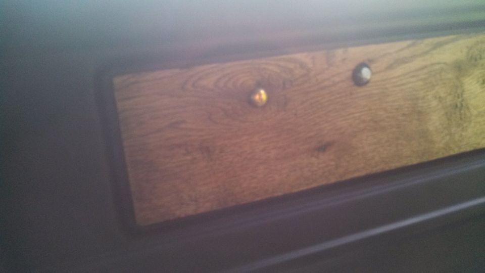 Interior wood trim panel with two decorative knobs