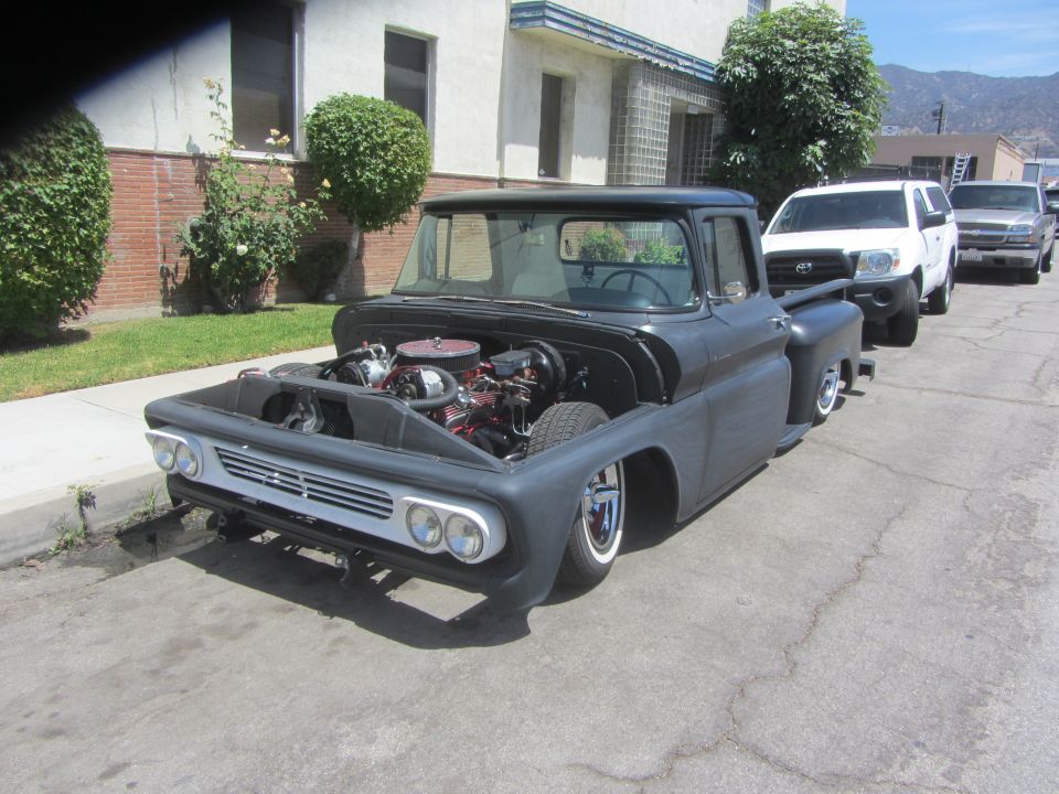 Customized pickup truck, front view, hood open, showing engine. Whitewall tires and lowered stance
