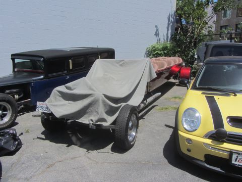 1968 Ford Mustang - A trailer with a tarp covering its contents is parked between a hot rod and a yellow Mini Cooper.