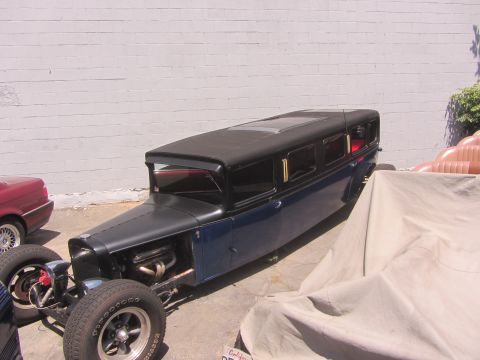 1968 Ford Mustang - A custom-built hot rod limousine with a distinctive long body and exposed engine is seen outdoors.