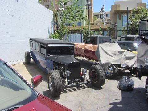 1968 Ford Mustang - This custom hot rod limousine is parked next to other vehicles in an outdoor lot.