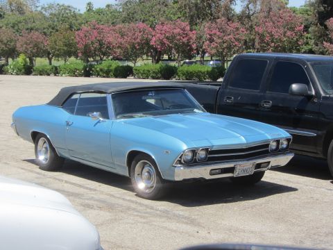 1968 Ford Mustang - A light blue convertible with a black top is parked in a lot next to a black pickup truck.