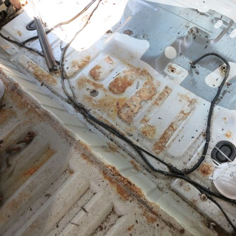 1995 Ford Bronco - The interior floor pan shows significant rust and exposed wiring, indicating potential restoration needs.