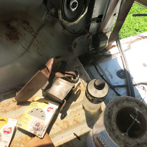 1995 Ford Bronco - Supplies are stored inside the interior of a vehicle, including a speaker and sandpaper.