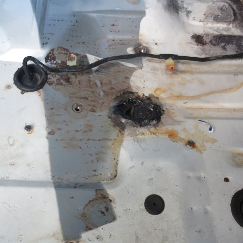 1995 Ford Bronco - This photo shows the corroded undercarriage of a vehicle with a hole that has been sealed.