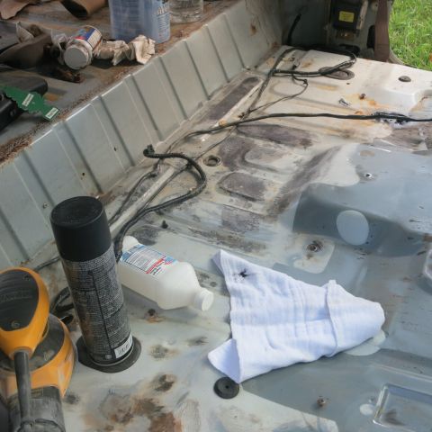 1995 Ford Bronco - Vehicle interior stripped down for restoration, with cleaning supplies and tools laid out on the floor.