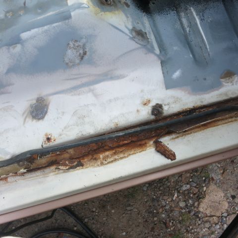 1995 Ford Bronco - The door frame of the vehicle shows extensive rust damage, particularly around the weather stripping area.
