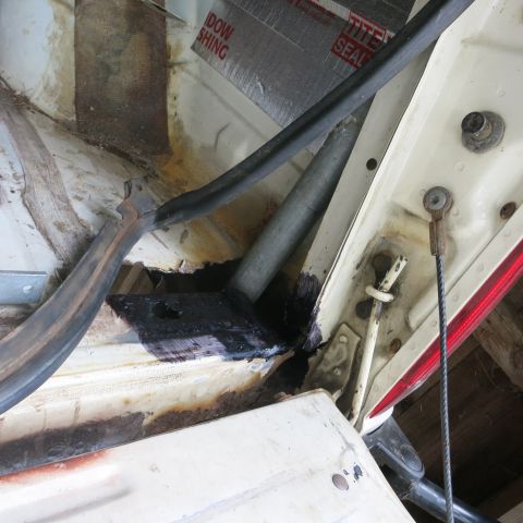 1995 Ford Bronco - Close-up of the interior cargo area of a vehicle, revealing signs of wear and rust.