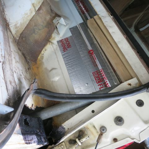 1995 Ford Bronco - Close-up of vehicle interior showing window flashing and insulation materials being applied during a repair or restoration process.
