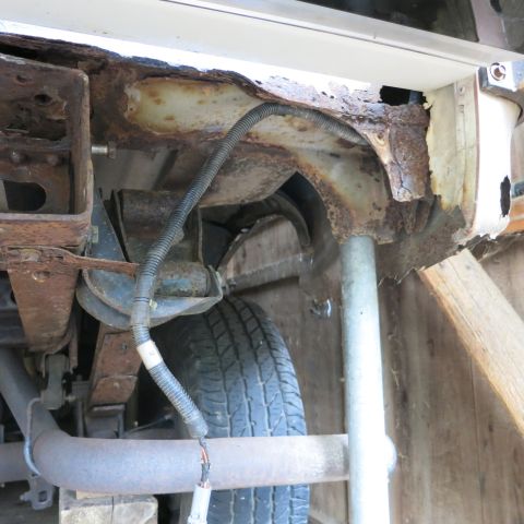 1995 Ford Bronco - Severe rust damage is visible on the vehicle's frame and suspension components.