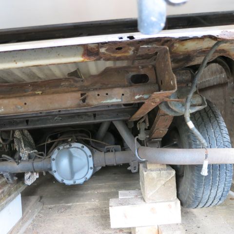 1995 Ford Bronco - The rear axle and suspension components of a vehicle are visible, supported by wooden blocks.