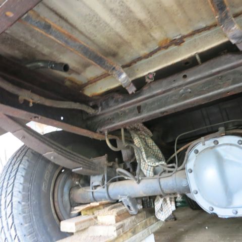 1995 Ford Bronco - Undercarriage view showing the rear axle, leaf springs, and fuel lines of a vehicle.